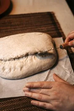 Scoring raw homemade bread dough with a special tool 写真素材