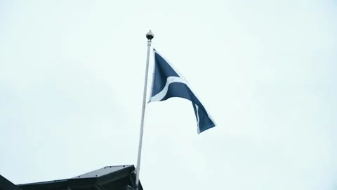 Scottish Flag blowing in the wind above the arcades in  Scotland Stock Footage