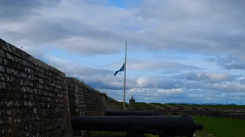 Scottish flag waves in half to Fort george Stock Footage 79569081