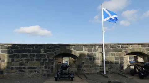 Scottish flag waving over a cannon in the Edinburgh castle, Scotland Stock Footage 322074197