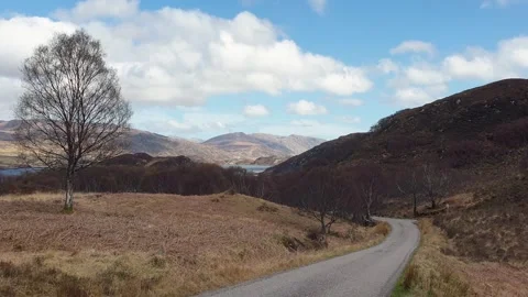 Scottish Outer Hebrides mountainous landscape winding road towards loch of Stock Footage 305536110