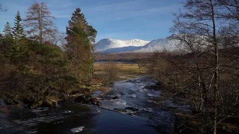 Scottish River View, snow mountains &amp; blue skies, trees and water, Scotland Stock Footage 79846480