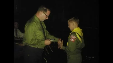 Scoutmaster awarding merits to boy scouts in 1967 Stock Footage 326896906