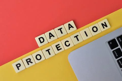 Scrabble letters with text DATA PROTECTION over yellow and red background. 写真素材