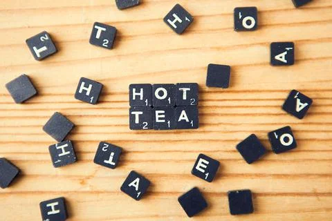 Scrabble. Table game. Hot tea words. Scrabble character on wood background Stock Photos