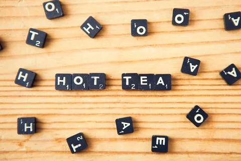 Scrabble. Table game. Hot tea words. Scrabble character on wood background Stock Photos