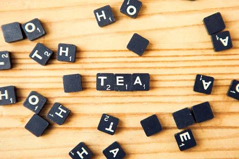 Scrabble. Table game. Tea word. Scrabble character on wood background Stock Photos