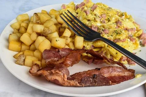 Scramble egg with chop ham  with bacon and hash browns, Foto stock