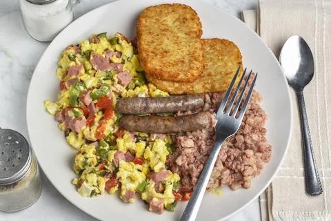 Scramble eggs  with  corn beef hash and  sausages Foto stock