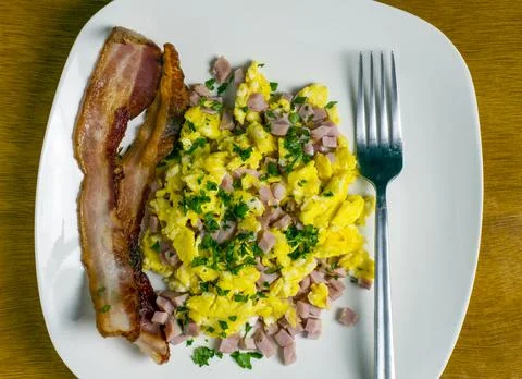 Scramble eggs top with diced ham and parsley Stock-Fotos