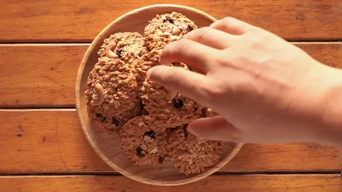 The scramble hand picked the cookie out of the wooden plate. Stock Footage 122168496