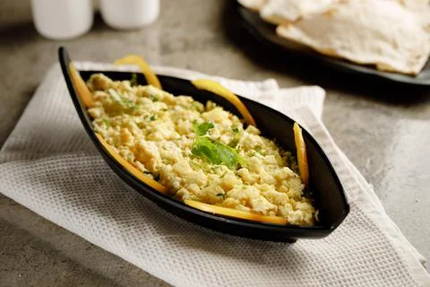 Scrambled egg with cheese served in a dish isolated on grey background side v Foto stock