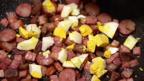 Scrambled egg cooking process with meat in a frying pan Stockbeeldmateriaal 250614023