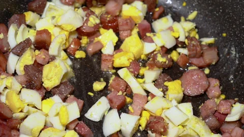 Scrambled egg cooking process with meat in a frying pan Stockbeeldmateriaal 250614163