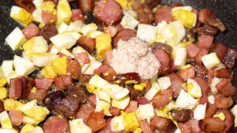 Scrambled egg cooking process with meat in a frying pan Stockbeeldmateriaal 250614218