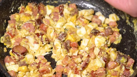 Scrambled egg cooking process with meat in a frying pan Stockbeeldmateriaal 250615059