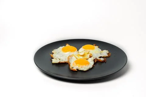 Scrambled eggs from 3 eggs on gray plates on white background Stock Photos