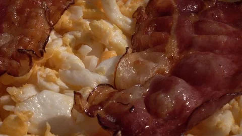 Scrambled eggs and fried crispy bacon, fading rotating to stop close up. Stock Footage 99851251