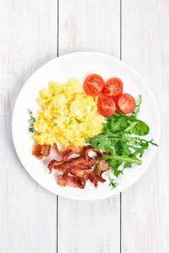 Scrambled eggs, bacon and vegetable salad Stock Photos