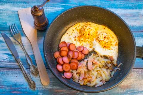 Scrambled eggs with bacon, onion and sausage. Stock Photos