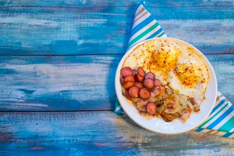 Scrambled eggs with bacon, onion and sausage. Stock Photos