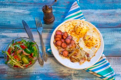 Scrambled eggs with bacon, onion and sausage. Stock Photos