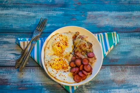 Scrambled eggs with bacon, onion and sausage. Stock Photos