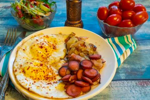 Scrambled eggs with bacon, onion and sausage. Stock Photos