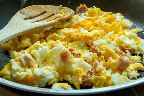 Scrambled eggs with bacon in a pan Stock Photos