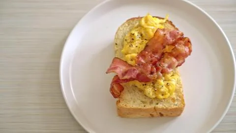 Scrambled eggs with bacon on a slice of bread Stock Photos