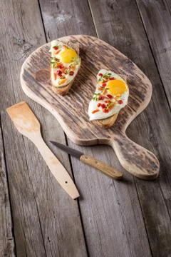 Scrambled eggs with bread on cutting board Stock Photos