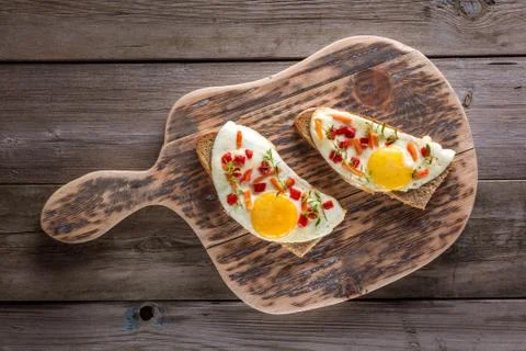 Scrambled eggs with bread on cutting board Stock Photos