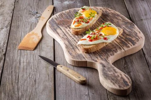 Scrambled eggs with bread on cutting board Stock Photos