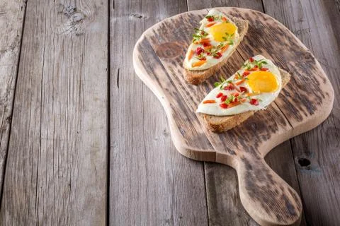 Scrambled eggs with bread on cutting board Fotos Stock