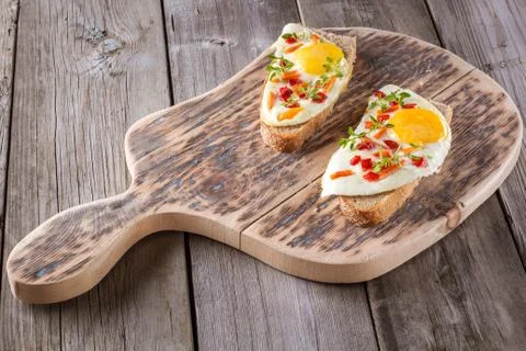 Scrambled eggs with bread on cutting board Stock Photos
