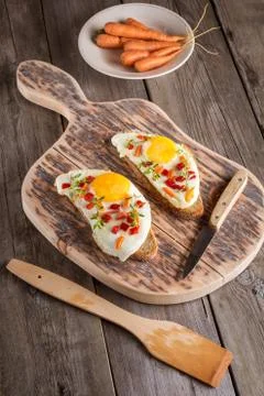Scrambled eggs with bread on cutting board Stock Photos