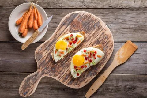 Scrambled eggs with bread on cutting board Stock Photos