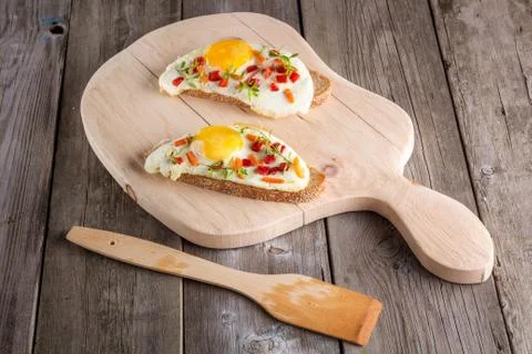 Scrambled eggs with bread on cutting board Stock Photos