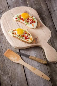 Scrambled eggs with bread on cutting board Stock Photos