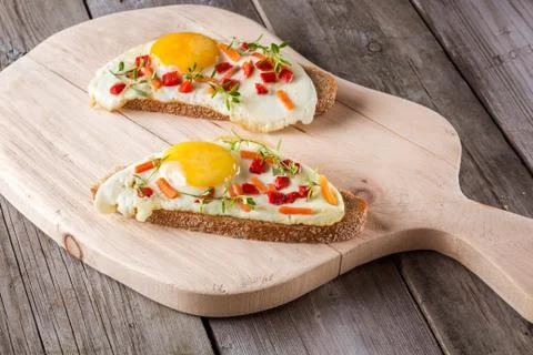 Scrambled eggs with bread on cutting board Fotos Stock