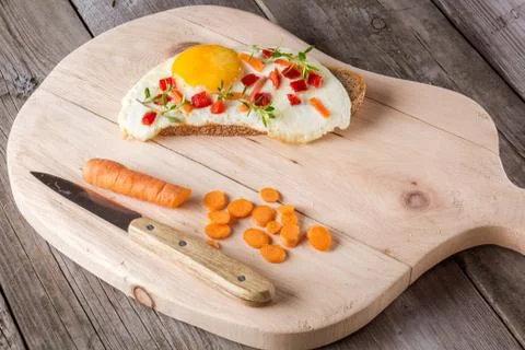 Scrambled eggs with bread on cutting board Stock Photos