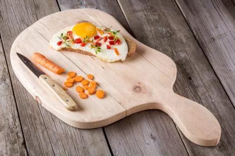 Scrambled eggs with bread on cutting board Stock Photos