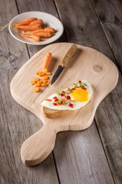 Scrambled eggs with bread on cutting board Fotos Stock