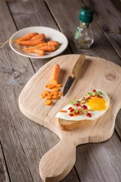 Scrambled eggs with bread on cutting board Stock Photos