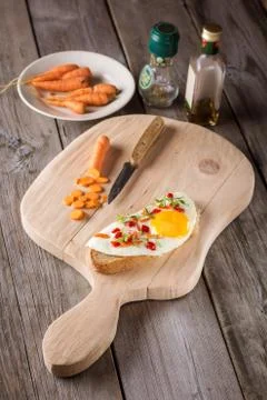 Scrambled eggs with bread on cutting board Stock Photos