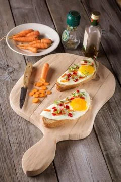 Scrambled eggs with bread on cutting board Stock Photos