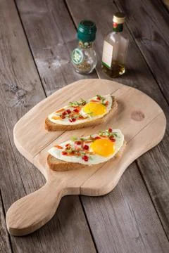 Scrambled eggs with bread on cutting board Stock Photos