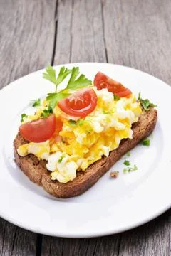 Scrambled eggs on bread Stock Photos