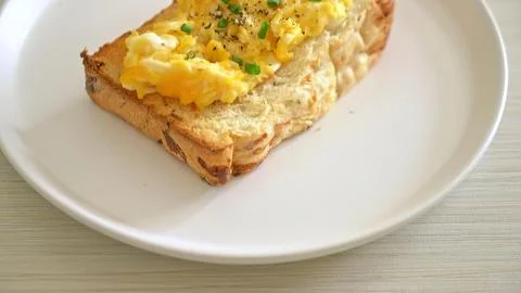 Scrambled eggs on bread toast with green onions on a plate Stock Photos