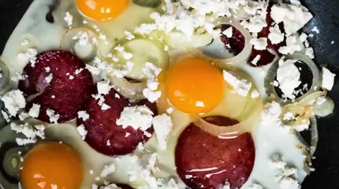 Scrambled eggs with cheese and salami in a pan Stock Footage 49928912